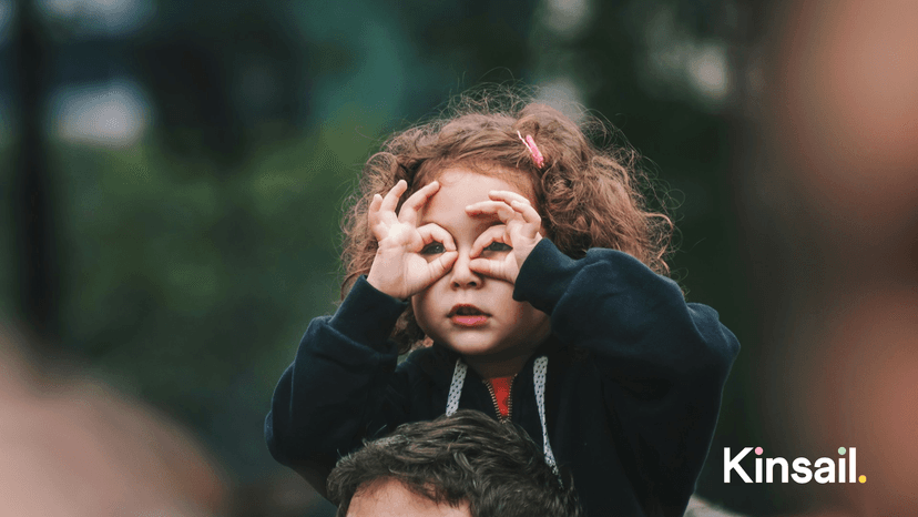 a kid on their parents shoulders
